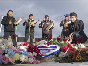 Prime Minister Justin Trudeau lays flowers at a memorial at La Loche Community School on January 29, 2016.