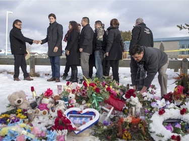 Prime Minister Justin Trudeau lays flowers at a memorial at La Loche Community School on January 29, 2016.