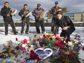 Prime Minister Justin Trudeau lays flowers at a memorial at La Loche Community School on Jan. 29, 2016.