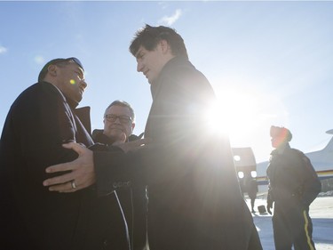 Prime Minister Justin Trudeau (R) speaks with Barry Poulegour while he is greeted by people from La Loche after arriving at the airport on January 29, 2016.