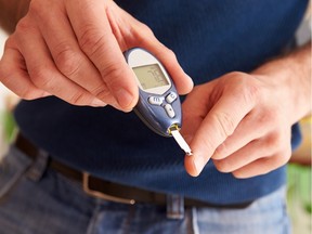 Male diabetic checking blood sugar levels .