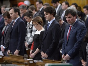 Prime Minister Justin Trudeau (centre) and Liberal MPs stand for a moment of silence for the Saskatchewan shooting victims during Question Period in the House of Commons on Parliament Hill in Ottawa, on Monday, Jan.25, 2015.