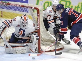 Connor Ingram (39) holds off Regina Pats' Adam Brooks (77) in Regina on December 15, 2015.