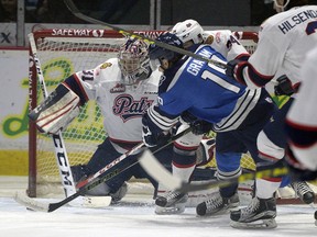 Pats goaltender Tyler Brown covers the net as Blades Ryan Graham tries to put it in the corner during WHL action between the Regina Pats and Saskatoon Blades in Regina.