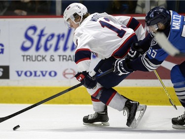 Pats' Riley Woods and Blades' Colton Waltz battle for the puck during WHL action between the Regina Pats and Saskatoon Blades in Regina.