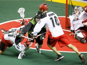 Robert Church of the Saskatchewan Rush is sandwiched between Brandon Goodwin (L) and Curtis Manning of the Calgary Roughnecks in Calgary on Saturday,. It was the season opener for both teams.