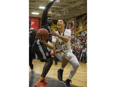 Archbishop O'Leary Spartans' Mina Ogot (L) attempts to stop Garden City Collegiate Fighting Gophers' Marcel Arruda-Welch at the annual BRIT basketball classic, January 9, 2016.