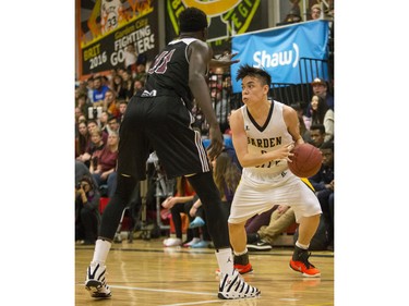 The Archbishop O'Leary Spartans' Adong Makuoi (L) guards Garden City Collegiate Fighting Gophers' Trezon Morcilla as he heads to the basket at the annual BRIT basketball classic, January 9, 2016.