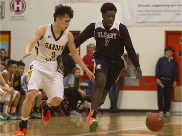 Archbishop O'Leary Spartans' Mina Ogot (R) moves the ball against Garden City Collegiate Fighting Gophers' Trezon Morcilla at the annual BRIT basketball classic, January 9, 2016.