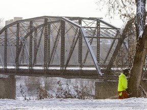 A worker removes a tree from the north end of the Traffic Bridge in Saskatoon, January 14, 2016. Work has begun to remove the northernmost span of the condemned bridge.