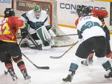 University of Saskatchewan goalie Jordon Cooke makes a save against the University of Calgary Dinos in CIS men's hockey action, January 16, 2016.