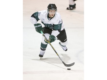 University of Saskatchewan defence  Connor Cox moves the puck against the University of Calgary Dinos in CIS men's hockey action, January 16, 2016.