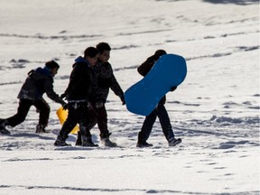 School children race up and down the sledding hill in Lief Erickson Park getting out in the sunshine shine and warmer temperatures,  in Saskatoon, January 22, 2016.