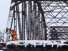 A worker prepares the Traffic Bridge Thursday for Sunday's demolition. The two southernmost spans of the historic bridge are scheduled to be toppled with explosive charges at 9 a.m.