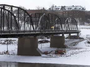 Surveyors work near the Traffic Bridge Friday morning. The two southernmost spans of the bridge are slated to be toppled with explosives Sunday morning at 9 a.m.