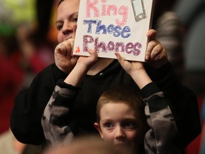 SASKATOON, SK - March 8, 2015 - Audience members hold signs saying ring those phones at Telemiracle 39 at TCU Place in Saskatoon on March 8, 2015. (Michelle Berg / The StarPhoenix)