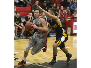 Brett McMurtry of the Bedford Road Collegiate RedHawks (L) drives against Mina Ogot of the Garden City Fighting Gophers during opening game action in the annual BRIT basketball classic, January 7, 2016.