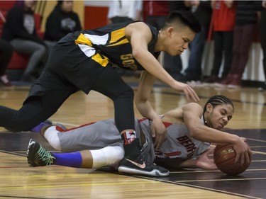 Justyn Lightle of the Bedford Road Collegiate RedHawks (at bottom) struggles for the ball against Dylan Tagle of the Garden City Fighting Gophers during opening game action in the annual BRIT basketball classic, January 7, 2016.