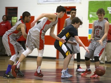 Members of the Bedford Road Collegiate RedHawks (red colours) shut down Jordan Kashton of the Garden City Fighting Gophers during opening game action in the annual BRIT basketball classic, January 7, 2016.