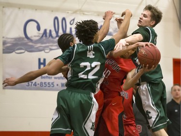 Ahmed Ali  of the Bedford Road Collegiate RedHawks, red colours, is crushed between Savion Tyson and Andrew Bryant of  the Holy Cross Crusaders during the annual BRIT basketball classic  Friday, January 08, 2016.