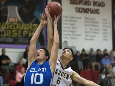 Eric Turcotte of the Bishop James Mahoney Saints, blue, goes for the rebound with  Dylan Tagle of the Garden City Fighting Gophers during the annual BRIT basketball classic  Friday, January 08, 2016.