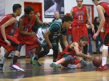 Justyn Lightle of the Bedford Road Collegiate RedHawks, red colours, goes for a posse ball against the Holy Cross Crusaders during the annual BRIT basketball classic  Friday, January 08, 2016.