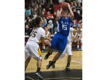 Luke Karwacki of the Bishop James Mahoney Saints, blue, goes for drive against Marcel Arruda-Welch of the Garden City Fighting Gophers during the annual BRIT basketball classic  Friday, January 08, 2016.
