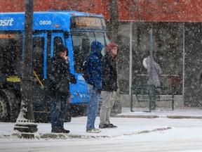 Commuters try to keep themselves warm while waiting for a bus in Saskatoon on Monday, January 18, 2016.