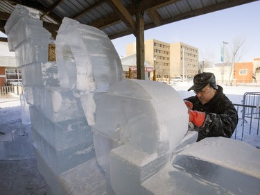 Tak Ito of Fire and Ice cuts into a block of ice while creating a sculpture for WinterShines at the Saskatoon Farmers' Market, January 19, 2016. WinterShines runs Jan 23-31.