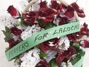 Sign on flowers outside the La Loche Community School Dene Building,  Jan. 26, 2016.