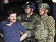 In this Friday, Jan. 8, 2016 photo, Joaquin "El Chapo" Guzman is made to face the press as he's escorted to a helicopter in handcuffs by soldiers and marines at a federal hangar in Mexico City.