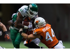 Saskatchewan Roughriders' Anthony Allen, left, is tackled by B.C. Lions' Adam Bighill during the first half of a CFL football game in Vancouver, B.C., on Friday July 10, 2015.