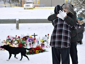 Residents console each other at the memorial near the La Loche Community School in La Loche, Sask., two days after the Jan. 22, 2016 shooting that left four people dead.