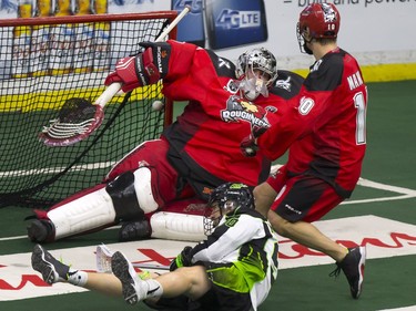 A sprawling Ben McIntosh of the Saskatchewan Rush scores past Frankie Scigliano of the Calgary Roughnecks during National Lacrosse League action in Saskatoon at SaskTel Centre, Friday, February 05, 2016.