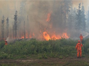 Firefighters battle a wildfire near La Ronge, Sask., on July 5, 2015