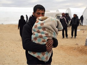 In this photo provided by Turkish Islamic aid group IHH, Syrians gather at a temporary refugee camp for displaced Syrians in northern Syria, near Bab al-Salameh border crossing with Turkey, Sunday, Feb. 7, 2016.