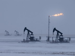 Pumpjacks in a field north of Kindersley as the sun goes down on Friday, Feb. 12, 2016.