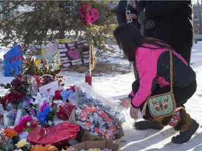 La Longe Indian Band Chief Tammy Cook-Searson lays flowers at a memorial at the La Loche Community High School on February 2, 2016.