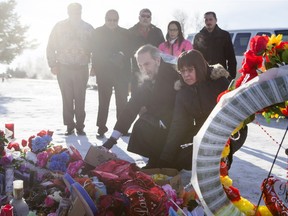 Local MP Georgina Jolibois (R) and NDP Leader Tom Mulcair lay flowers at a memorial at the La Loche Community High School on February 2, 2016.