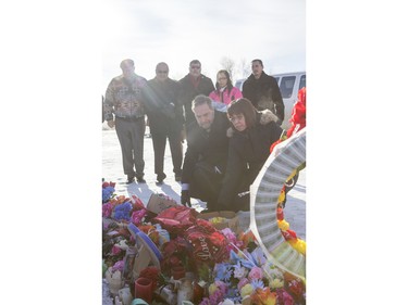 Local MP Georgina Jolibois (R) and NDP Leader Tom Mulcair lay flowers at a memorial at the La Loche Community High School on February 2, 2016.