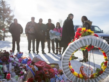 Local MP Georgina Jolibois (R) and NDP Leader Tom Mulcair lay flowers at a memorial at the La Loche Community High School on February 2, 2016.