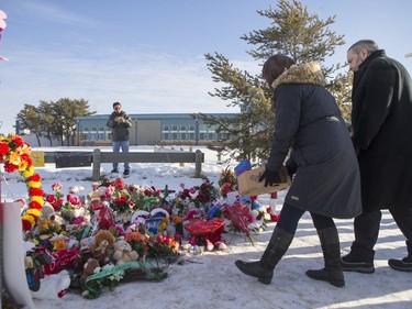 Local MP Georgina Jolibois (L) and NDP Leader Tom Mulcair lay flowers at a memorial at the La Loche Community High School on February 2, 2016.