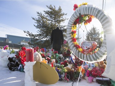 NDP Leader Tom Mulcair looks at some items and inscriptions after laying down flowers at a memorial at the La Loche Community High School on February 2, 2016.