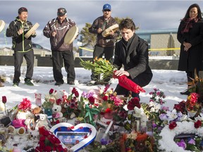 Prime Minister Justin Trudeau lays flowers at a memorial at La Loche Community School.