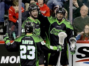 Saskatchewan Rush players Jarrett Davis, Dan Taylor and Zak Greer celebrate their overtime win against the Calgary Roughnecks in NLL action at the Scotiabank Saddledome in Calgary on Sunday.