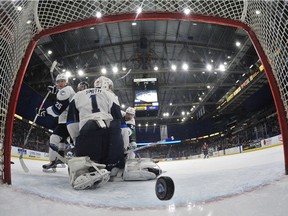 Saskatoon Blades' Libor Hajek (L) and goalie Evan Smith look back at the puck as the Moose Jaw Warriors score in WHL action, February 28, 2016.