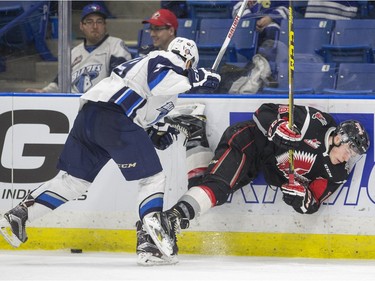 Saskatoon Blades' Nikita Soshnin knocks over Moose Jaw Warriors' Landon Quinney in WHL action, February 28, 2016.