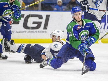 Swift Current Broncos forward Lane Pederson reaches for a puck on his knees after colliding with Saskatoon Blades forward Wyatt Sloboshan in WHL action  on Saturday, February 6th, 2016.