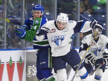 Saskatoon Blades forward Mason McCarty hits Swift Current Broncos defenceman  Kade Jensen into the boards in WHL action  on Saturday, February 6th, 2016.