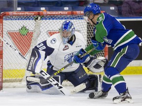 Saskatoon Blades goalie Brock Hamm makes a save against Swift Current Broncos defenceman Artyom Minulin in WHL action, February 6, 2016.